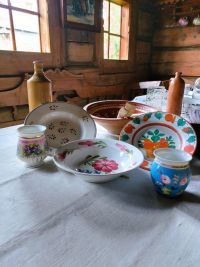 zastawa stołowa, naczynia malowane w kawiaty na białym obrusie
