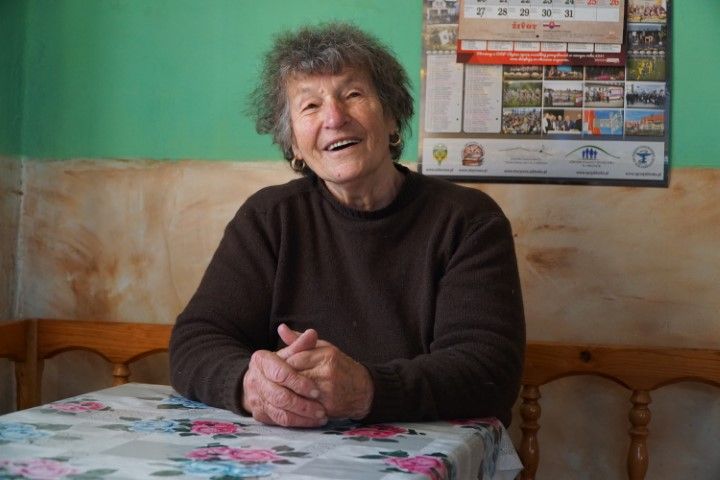Joanna Fuła - usmiechnięta starsza kobieta siedząca za stołem